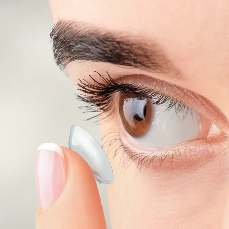 A patient putting a contact lens into her eye